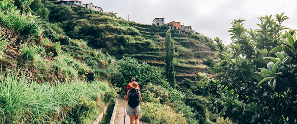 Escursionista su un sentiero tra le terrazze verdi di Madeira, trekking a Madeira 