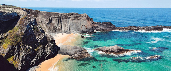Scogliera con acque turchesi, Algarve lungo la Rota Vicentina, Portogallo.