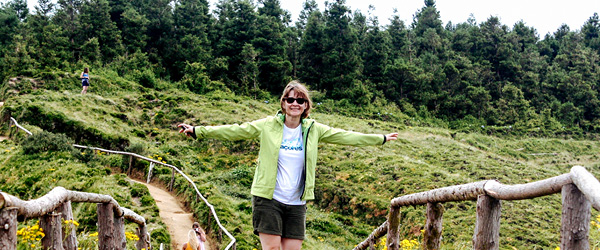 Escursionista su sentiero boschivo, vista panoramica tra le montagne, viaggio trekking indipendente alle Azzorre