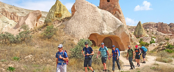 Gruppo di turisti che cammina tra le formazioni rocciose uniche della Cappadocia, viaggio di gruppo 