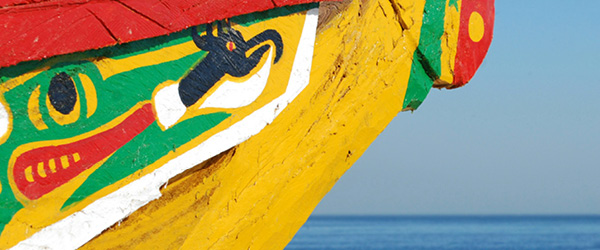 Piroga senegalese variopinta ormeggiata, simbolo dei villaggi di pescatori