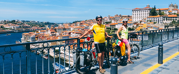 Ciclisti fermi sul ponte Dom Luís I con vista sul centro storico di Porto