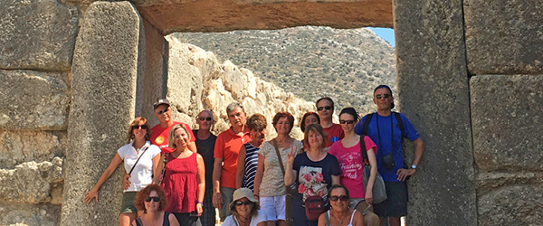 Gruppo di viaggiatori alla Porta dei Leoni di Micene, ingresso monumentale dell’antica cittadella micenea.