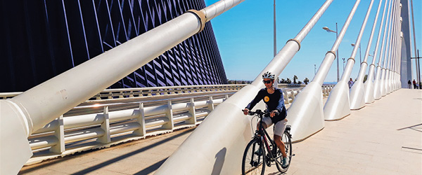 Ciclista Girolibero sul ponte moderno della Città delle Arti e delle Scienze di Valencia durante un tour in bici.