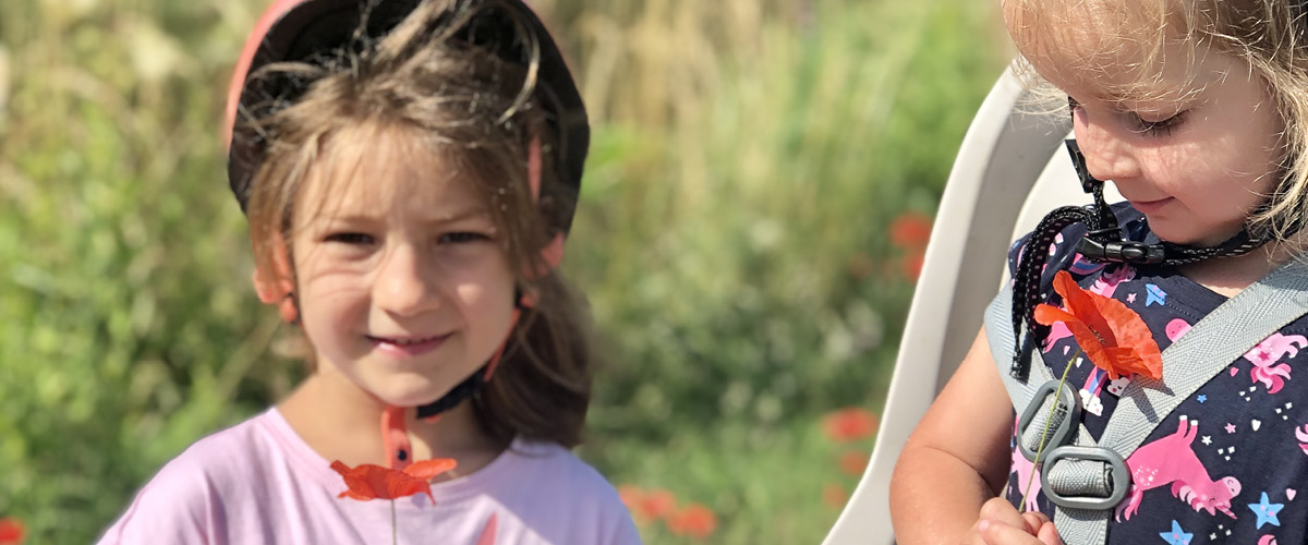 Due bambine in bici lungo un percorso ciclabile durante una pausa spuntino, Bretagna, Francia