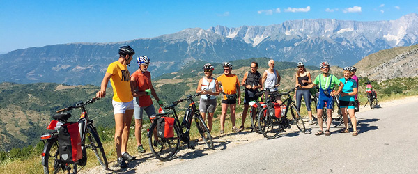Gruppo di cicloturisti con vista panoramica sulla Riviera Albanese e sul Mar Ionio lungo la strada costiera, Albania
