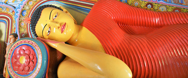 Statua di Buddha sdraiato decorata con dettagli colorati.