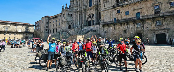 Gruppo di cicloturisti davanti alla Cattedrale di Santiago de Compostela in Plaza del Obradoiro, tappa finale del Cammino di Santiago in Galizia