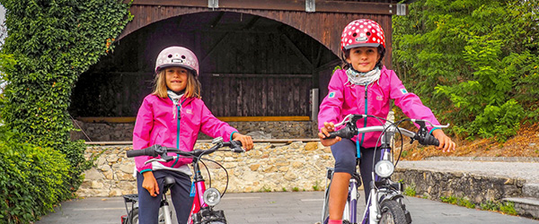 Bambine in bici con caschetto e giacca rosa, paesino austriaco lungo la ciclabile del Danubio tra Linz e Vienna