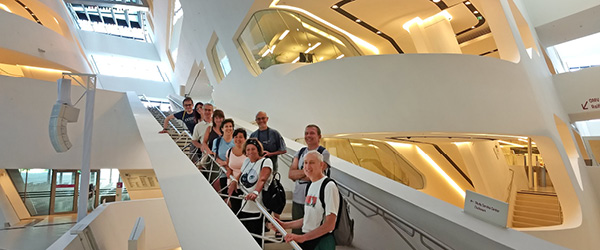 Interno della Facoltà di Economia di Vienna con scala monumentale e visitatori, esempio di architettura contemporanea e cultura urbana