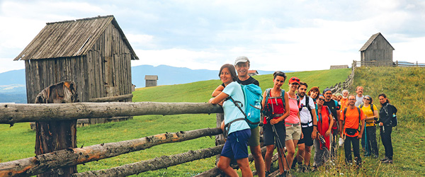 Gruppo di escursionisti in Romania, lungo sentiero rurale, viaggio a piedi nei Carpazi