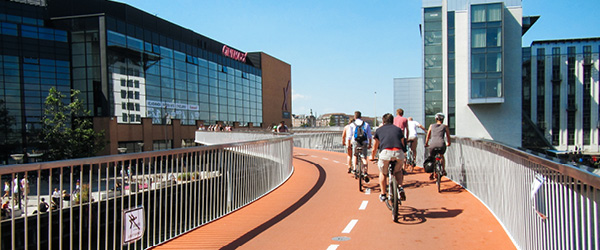 Ciclisti percorrono il ponte ciclabile rosso 