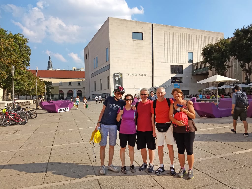 Gruppo di viaggiatori in posa nel MuseumsQuartier di Vienna, tour urbano a piedi tra architettura contemporanea e cultura