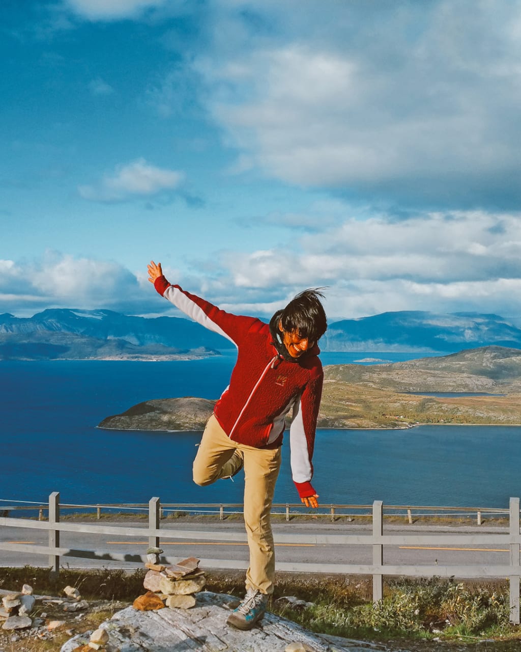 Escursionista in posa su una passerella panoramica in Norvegia.