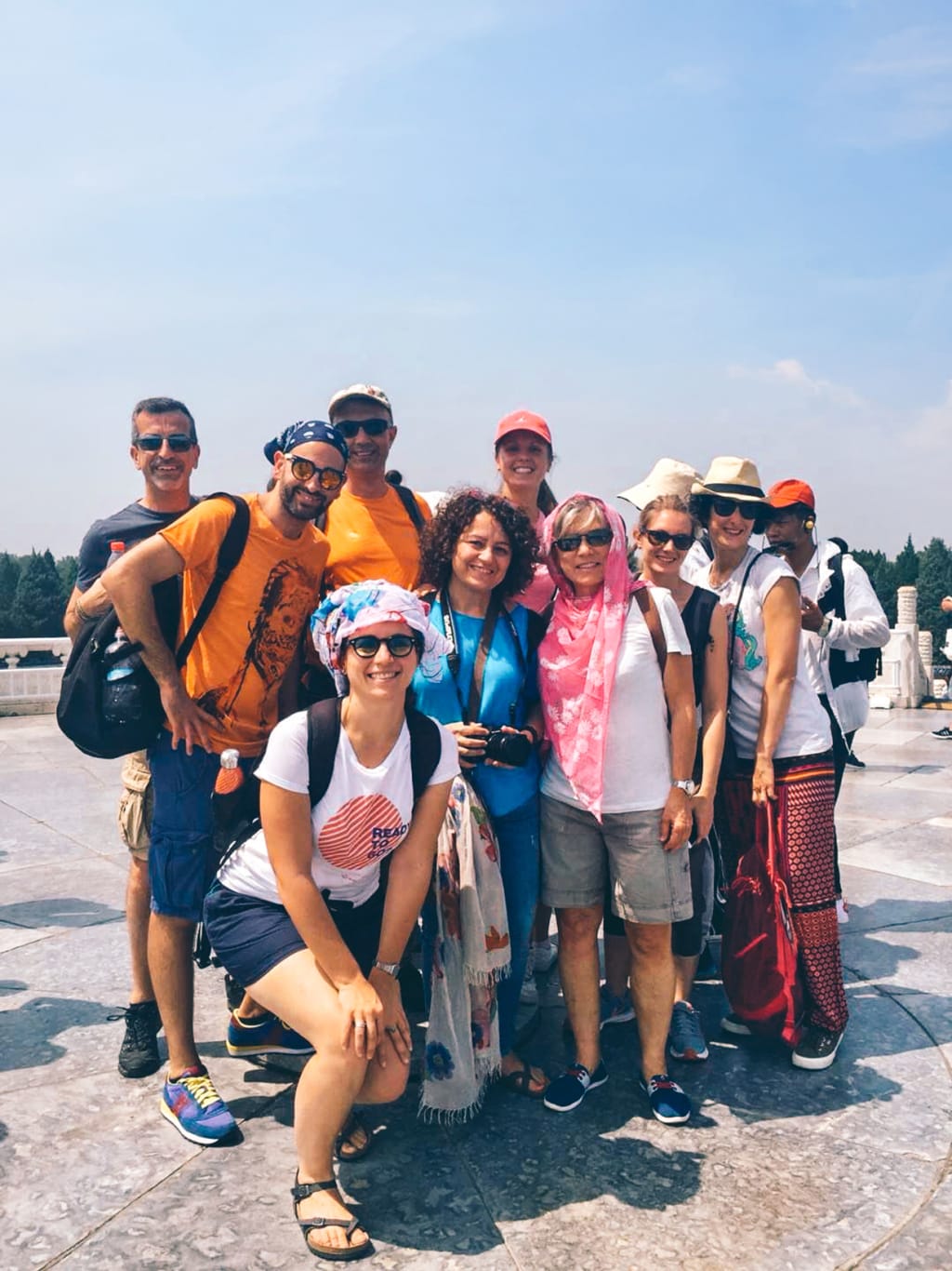 Gruppo di turisti in viaggio con Girolibero in visita a Piazza Tiananmen a Pechino, con abbigliamento estivo.