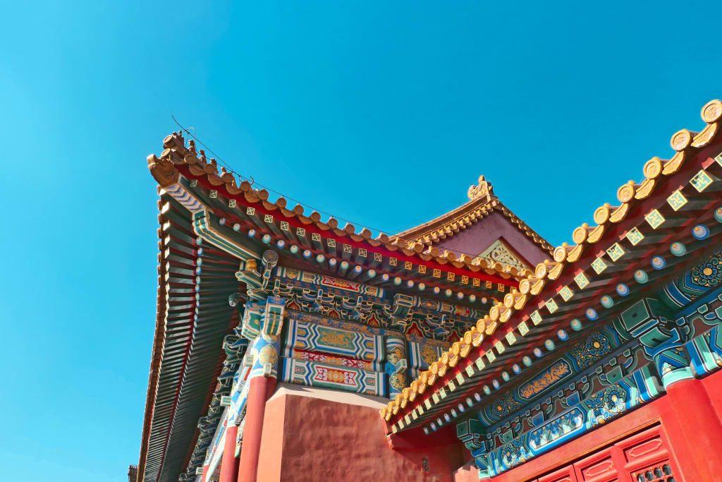 Dettaglio del tetto decorato del Palazzo d’Estate a Pechino con cielo azzurro sullo sfondo.