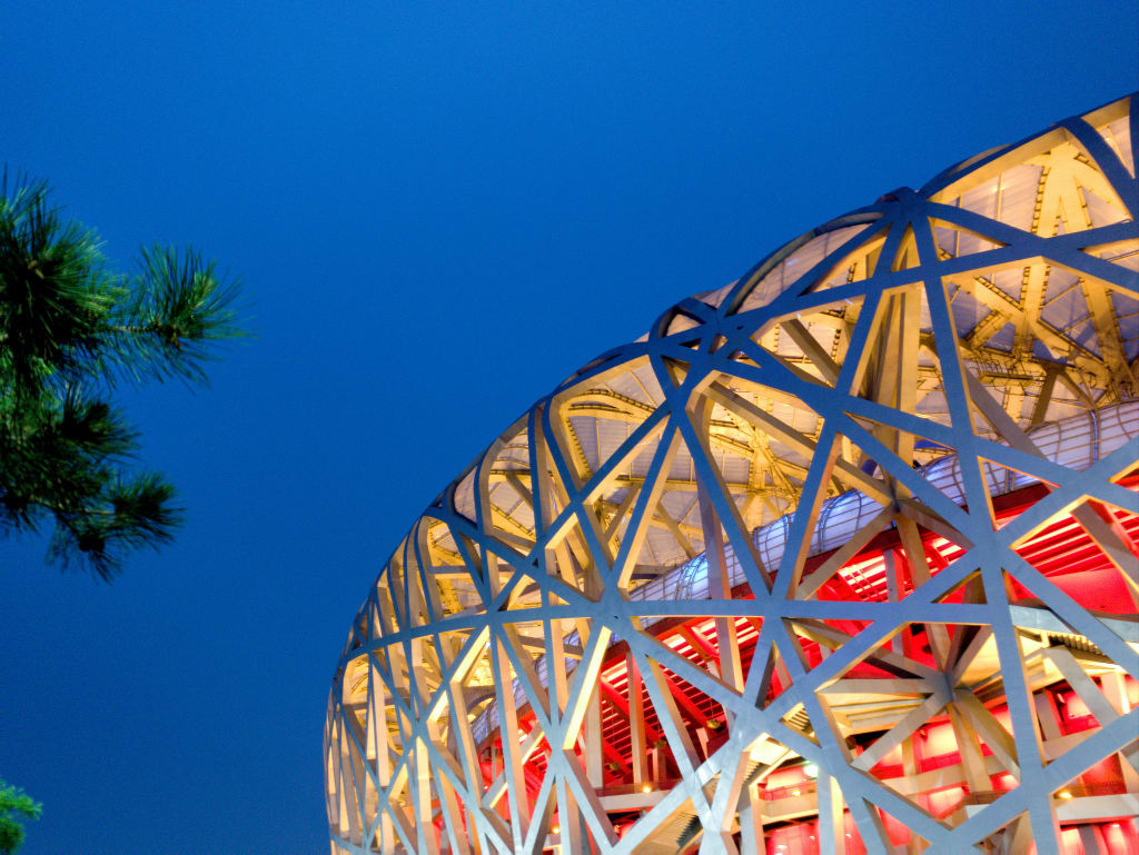 Vista del moderno Stadio Nazionale di Pechino, detto "Nido d'uccello", con cielo limpido.