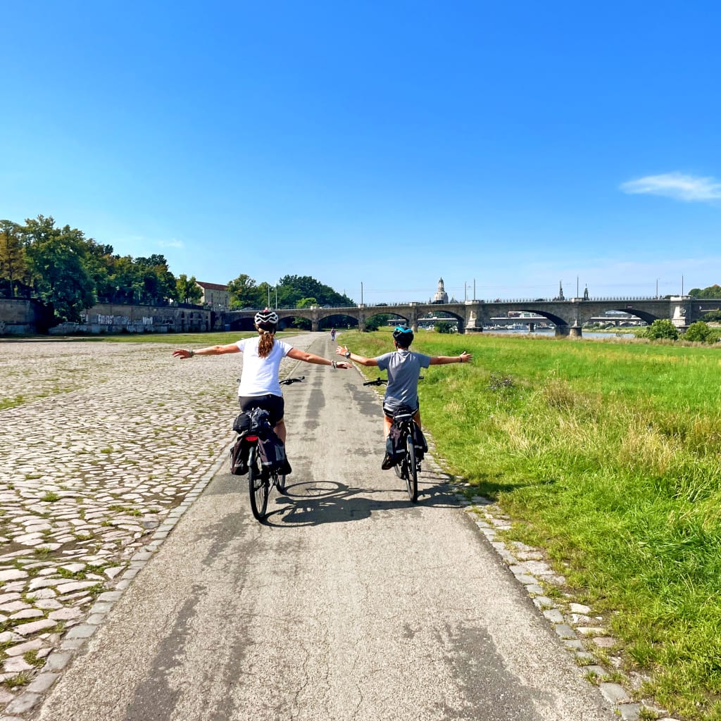 Famiglia in bicicletta su strada sterrata lungo la ciclabile dell'Elba e della Moldava