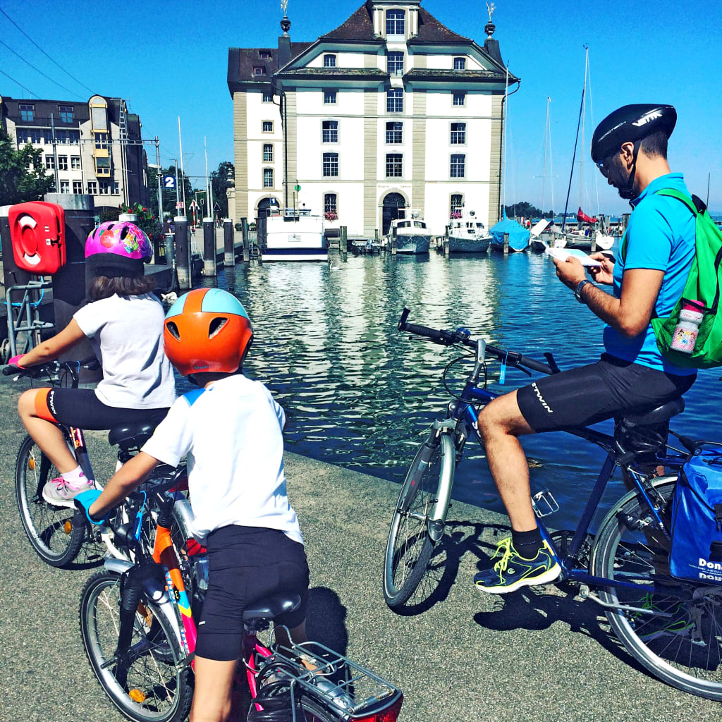 Famiglia in bicicletta vicino al castello di Meersburg sul Lago di Costanza.