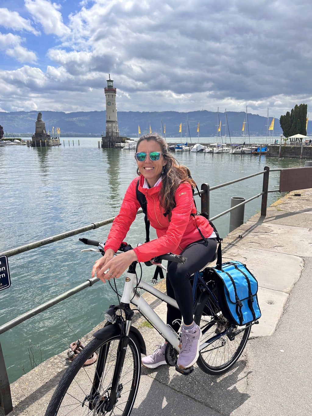 Donna sorridente in bicicletta lungo il lago di Costanza, Germania