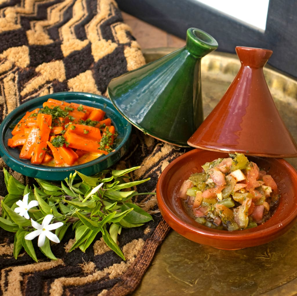 Tajine marocchini tradizionali serviti con verdure e spezie.