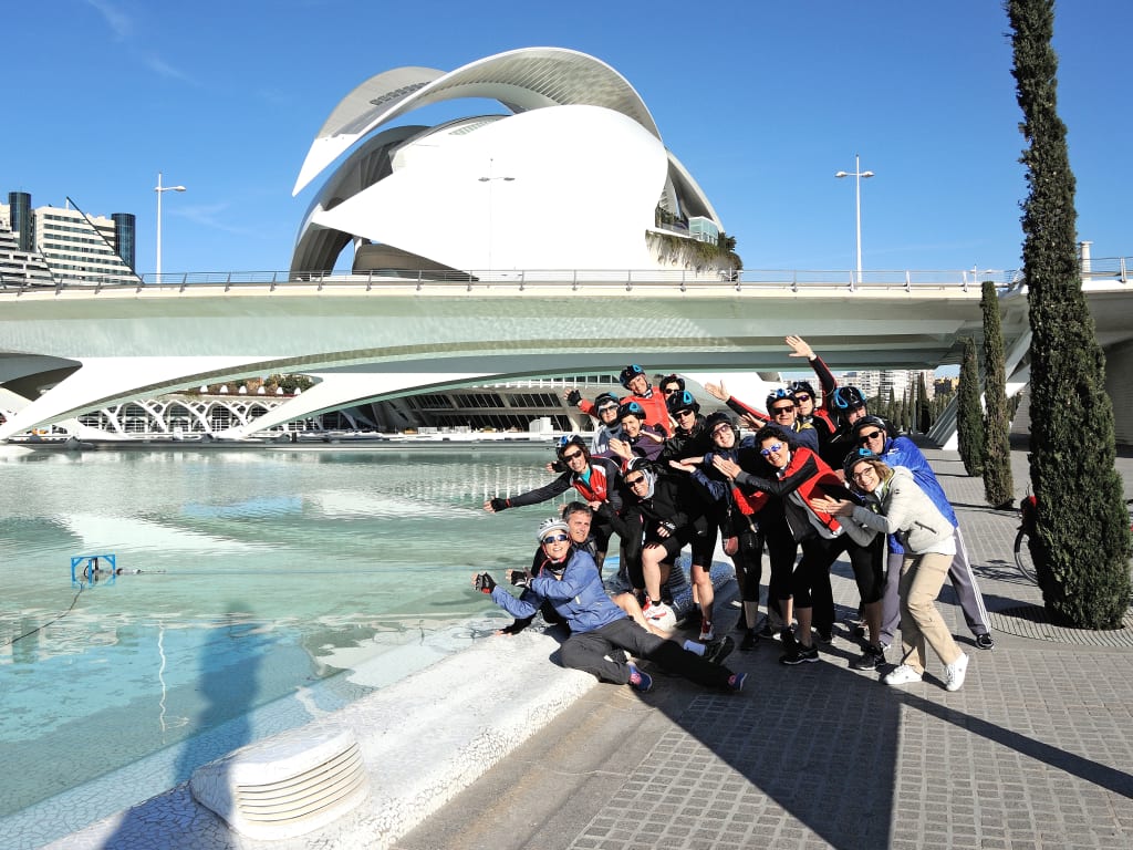Cicloturisti davanti al Palau de les Arts nella Ciutat de les Arts i les Ciències di Valencia, vacanza attiva in Spagna