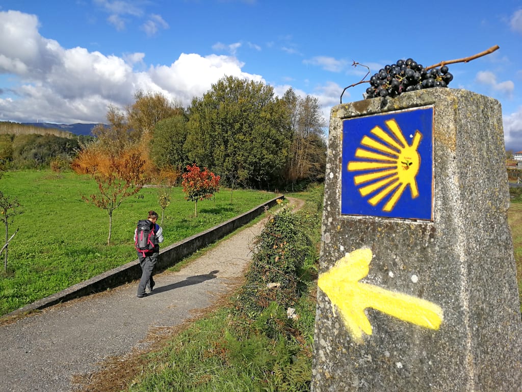 Pietra con concha e freccia gialla, simbolo del Cammino di Santiago