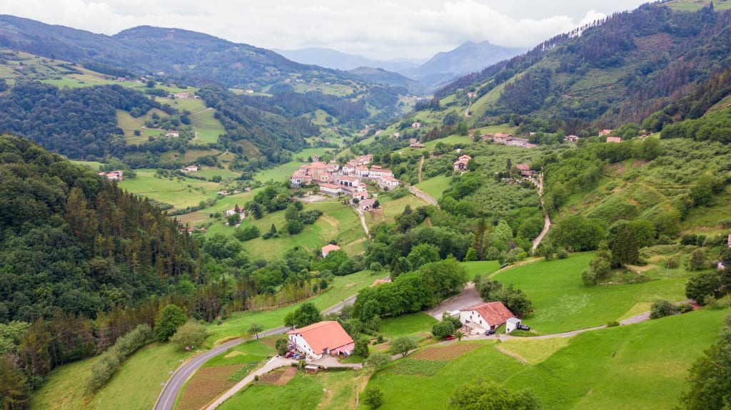 Paesaggio verde collinare con villaggio tipico, Paesi Baschi da scoprire in bicicletta