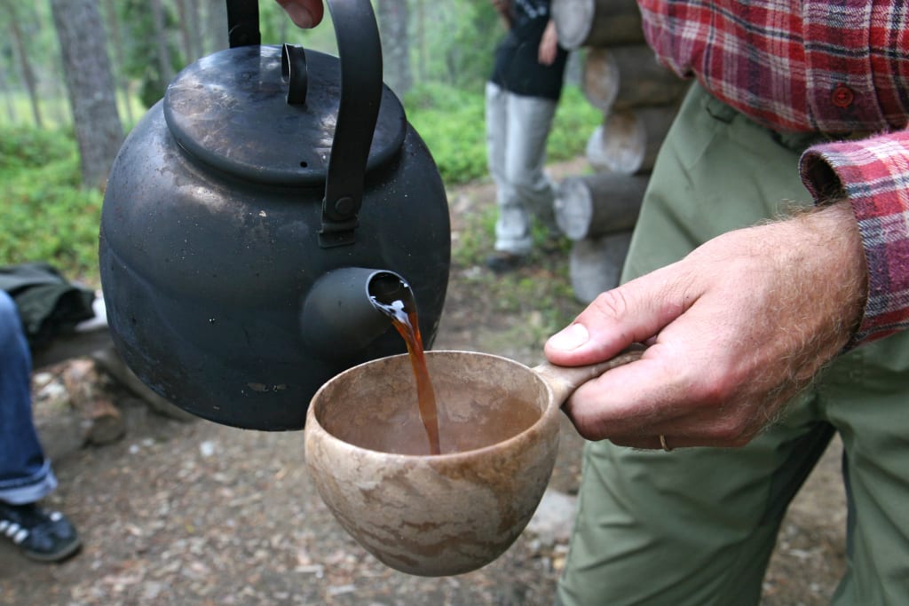 Infusione di bevanda calda su fuoco all’aperto in ambiente naturale finlandese