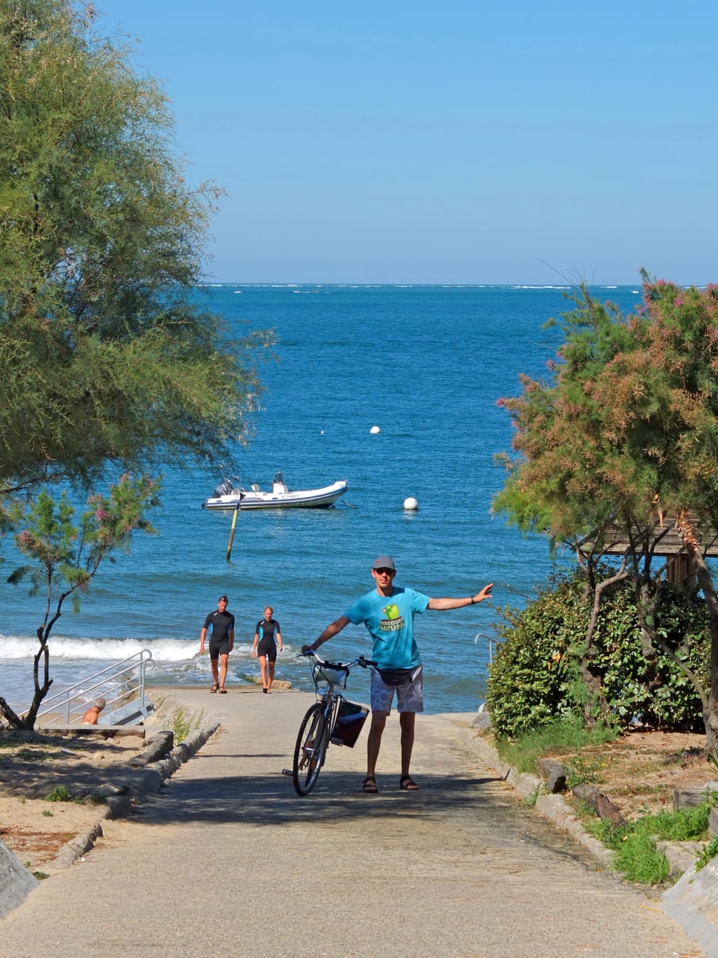 Spiaggia con ciclisti e barche sulla costa francese, baia di Arcachon