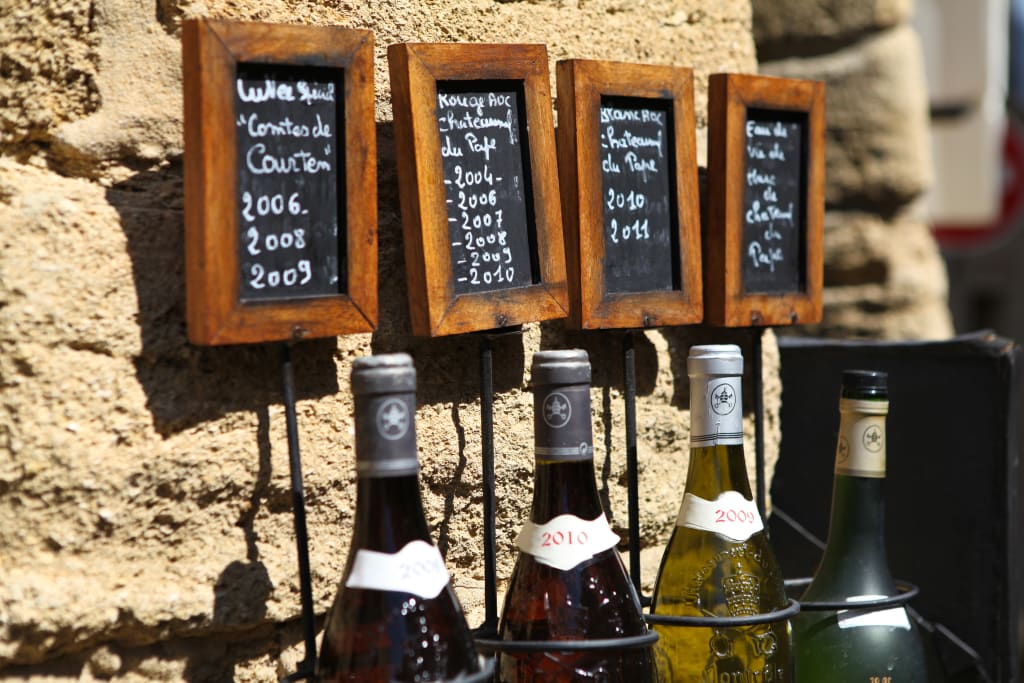 Bottiglie di vino artigianale esposte su una bancarella in Provenza, Francia.