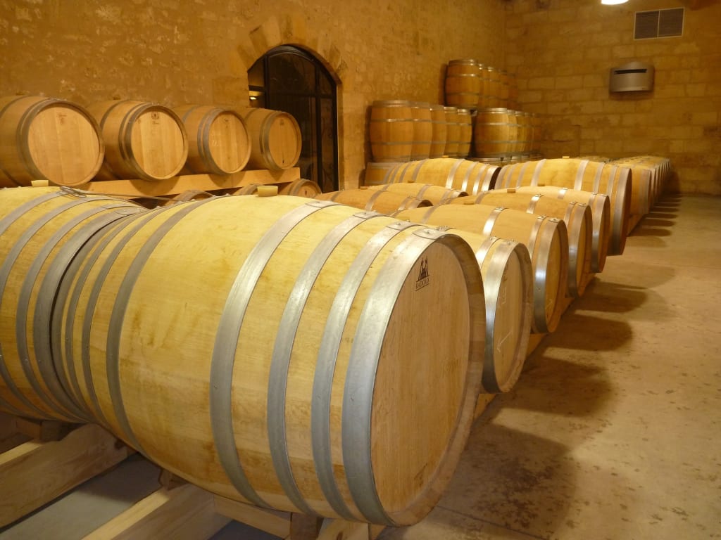 Interno di una cantina vinicola con barrique in legno per l’invecchiamento del vino a Bordeaux.