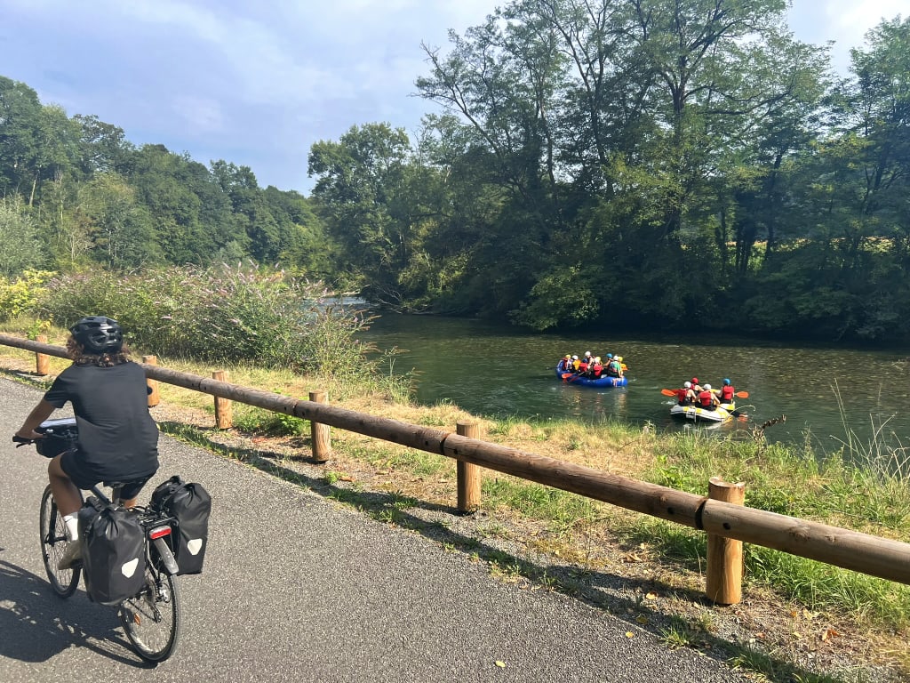 Ciclista su strada panoramica lungo un fiume nel sud della Francia, itinerario di cicloturismo nella natura