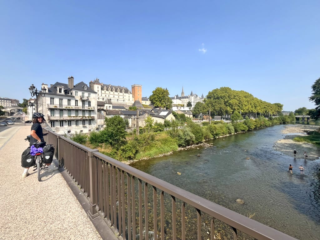 Ciclista sul ponte lungo il fiume in Francia, itinerario di un viaggio in bicicletta lungo la Velosud