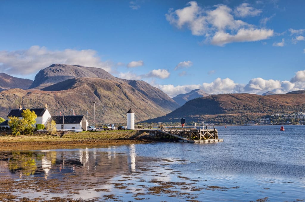 Panorama delle montagne delle Highlands scozzesi riflesso nelle acque tranquille di un lago sul percorso del Great Glen Way, viaggi organizzati, vacanze in Scozia