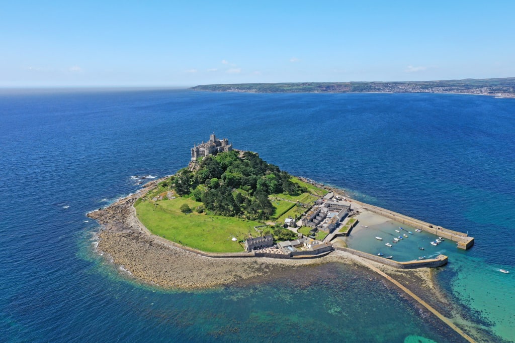 St Michael’s Mount, Cornovaglia – Isola tidale con un castello medievale al largo della costa della Cornovaglia, collegata alla terraferma da una strada percorribile con la bassa marea.