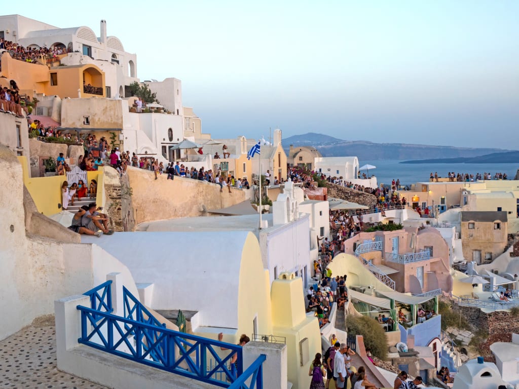 Porto di Santorini con barche ormeggiate e case colorate, Grecia.
