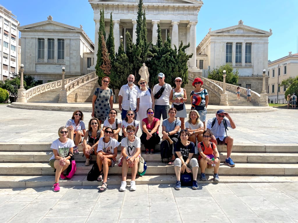 Gruppo di turisti davanti a un edificio neoclassico a Rodi, Grecia.