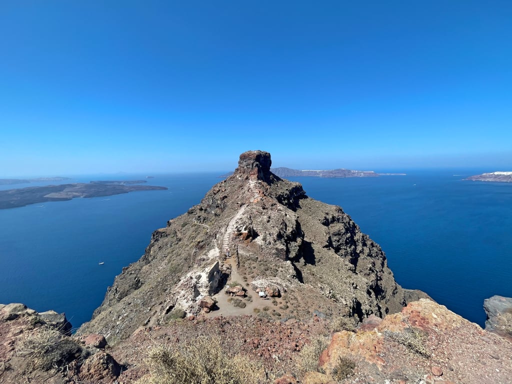 Vista dall'alto di una scogliera che si affaccia sul mare blu, Santorini, Grecia.