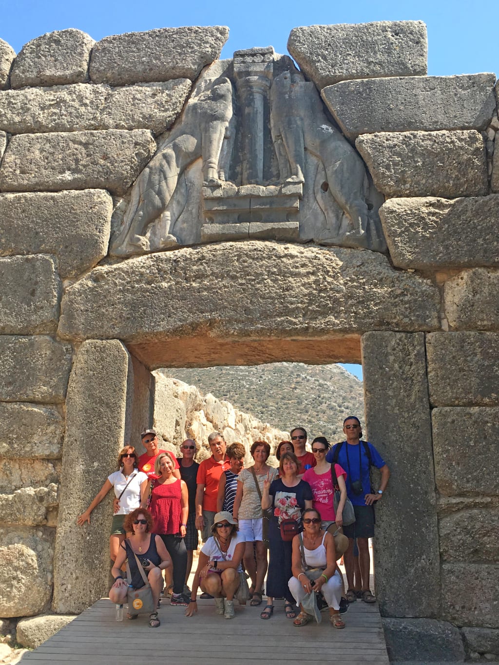 Gruppo di viaggiatori alla Porta dei Leoni di Micene, ingresso monumentale dell’antica cittadella micenea.