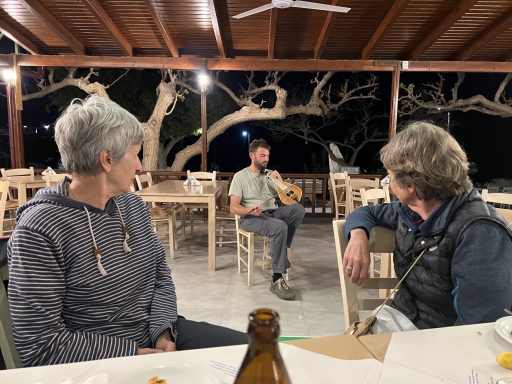 Serata in un ristorante con gruppo di viaggiatori, esperienza tradizionale in un villaggio dell’isola di Creta.