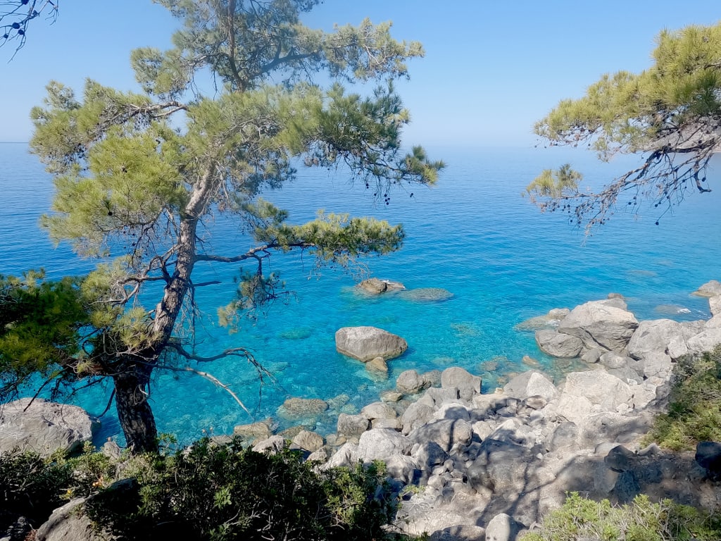 Vista panoramica della costa rocciosa e del mare blu dalla spiaggia di Glyka Nera, Creta, Grecia.