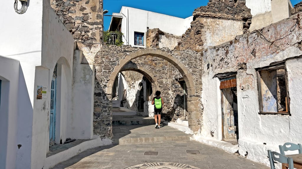 Caratteristica strada con archi in pietra e case bianche.
