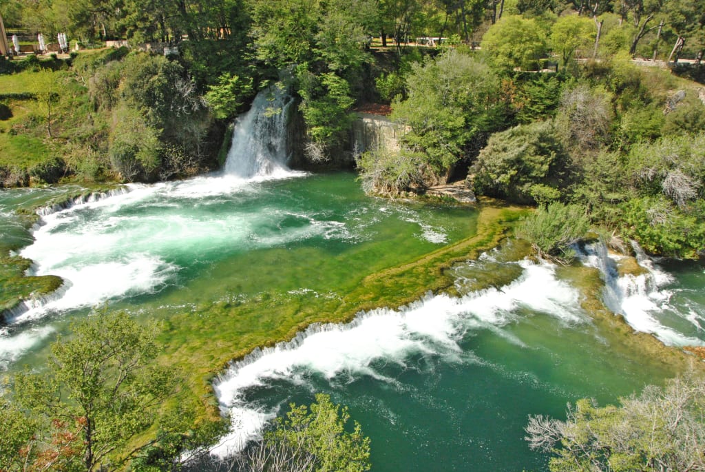 Cascate multiple nel Parco Nazionale dei Laghi di Plitvice con acqua verde smeraldo.