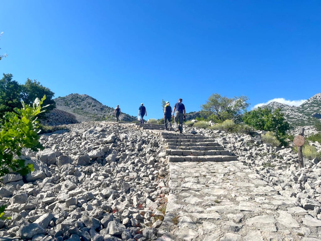 Visitatori su sentiero roccioso con vista panoramica sul Parco Nazionale di Krka, trekking in Croazia "Girolibero"