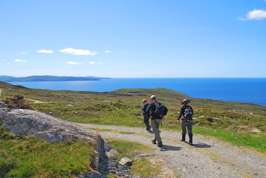 Coppia di escursionisti su un percorso vicino alla costa con vista sull'oceano tra Cork e Kerry.