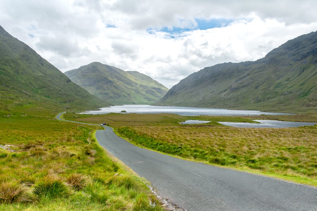 Strada panoramica tortuosa tra le montagne del Connemara, Irlanda, in una giornata nuvolosa.
