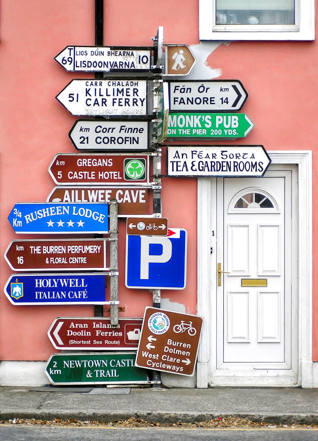 Cartelli turistici colorati a Doolin, Irlanda, con indicazioni per attrazioni come le Cliffs of Moher e il Burren.