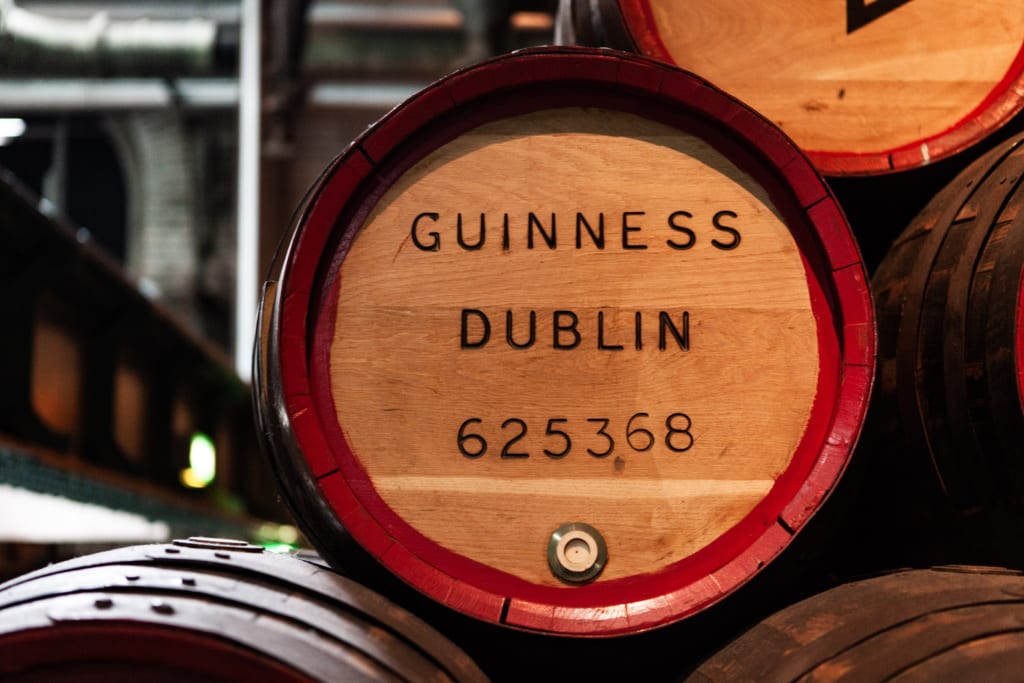 Botti di Guinness nel magazzino della fabbrica a Dublino, Irlanda, con logo inciso.