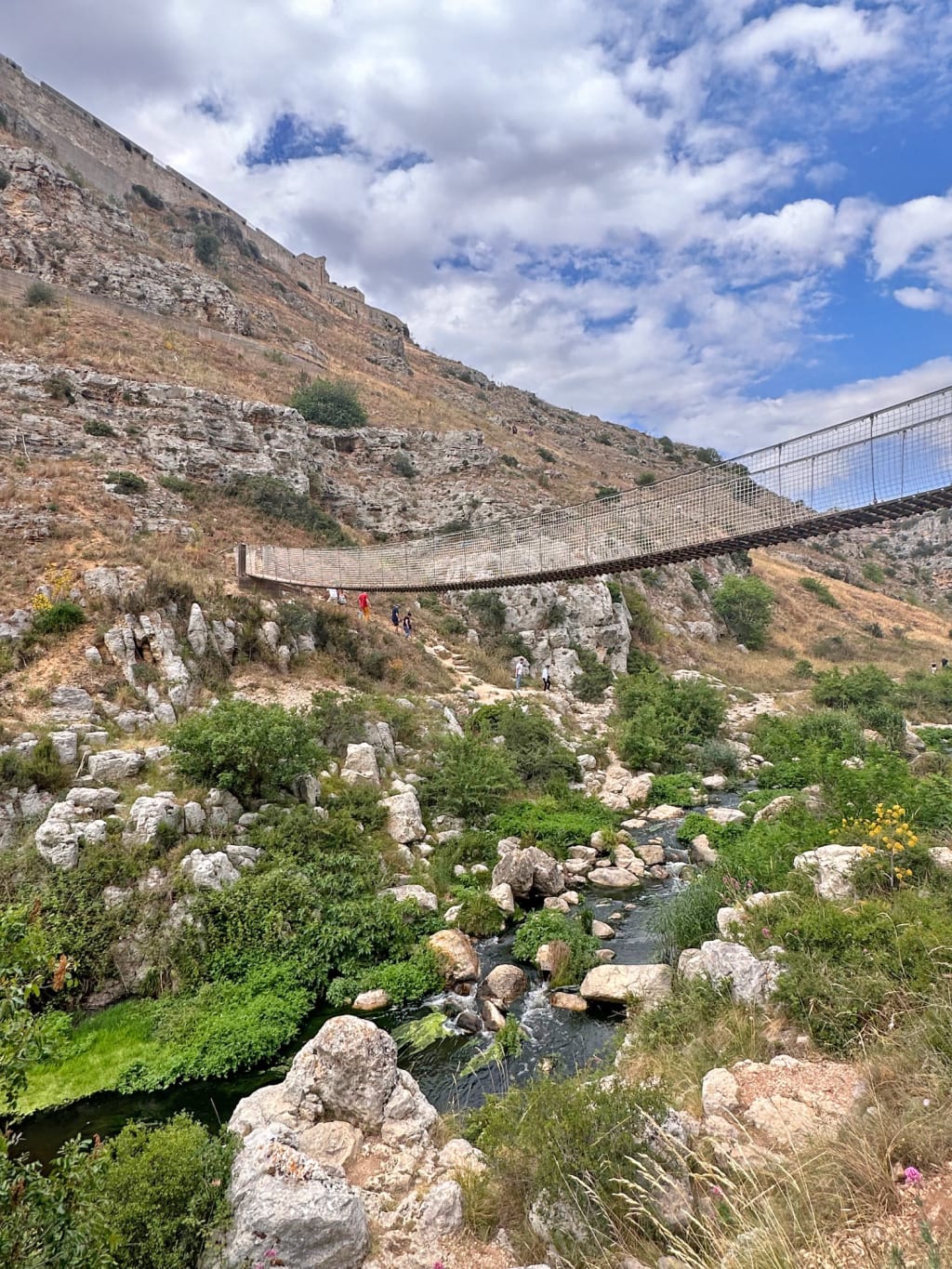 Gola rocciosa con ponte e torrente in Basilicata, escursione naturalistica durante un viaggio a piedi